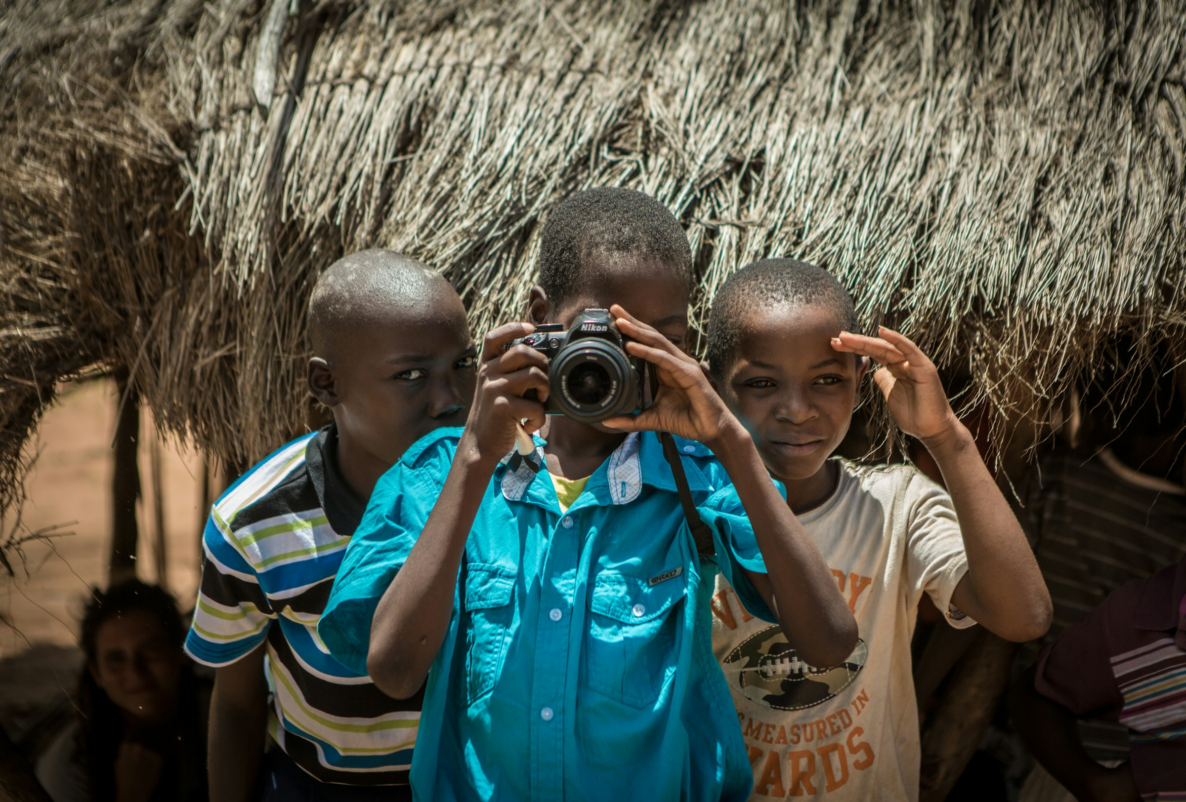 Young children playing with a camera.